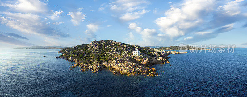 从上面看，令人惊叹的鸟瞰图的Vedetta di Punta Sardegna，一个白色的灯塔坐落在花岗岩，岩石海岸沐浴在蓝绿色的水。蓬塔撒丁尼亚，帕劳，撒丁岛，意大利。